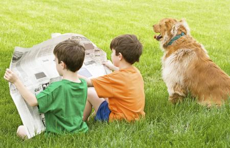 Children reading newspaper