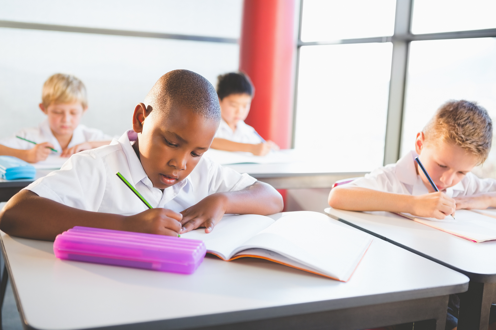 Classroom homework. Children in the Classroom. Kid in White uniform doing homework Happy. Finland pupils.