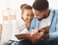 Child reading with father