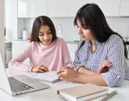 Mother helping child revise