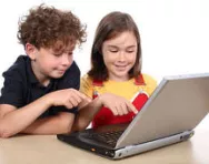 Brother and sister playing on laptop