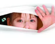 Child peeking through a hole
