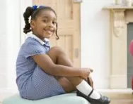 Girl in uniform doing up her shoes