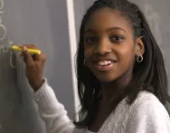 Girl writing on blackboard