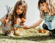 Two girls gardening with tools