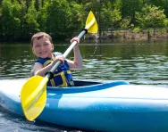 Summer camp boy kayaking