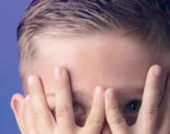 Boy hiding behind his hands