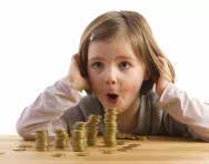 girl looking at pile of coins