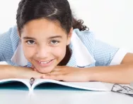 school girl lying on a book