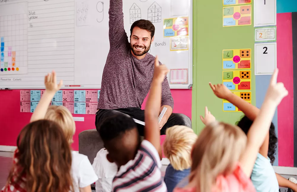 Children raising their hand in class 