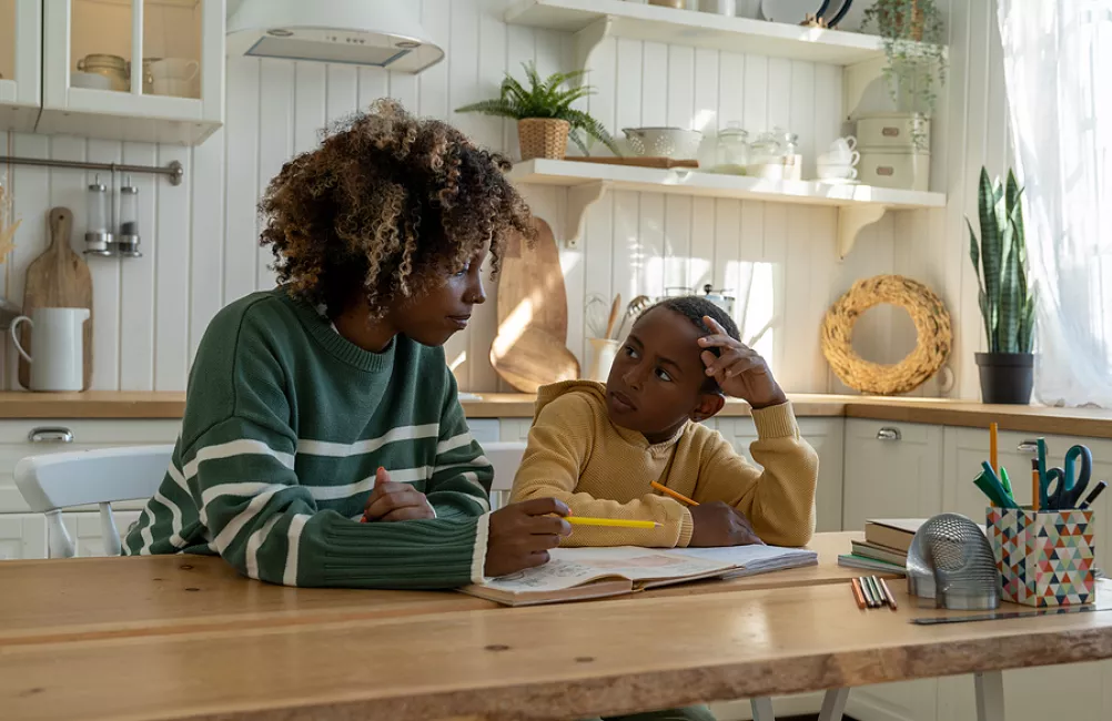 Mother helping child with homework BigStock image